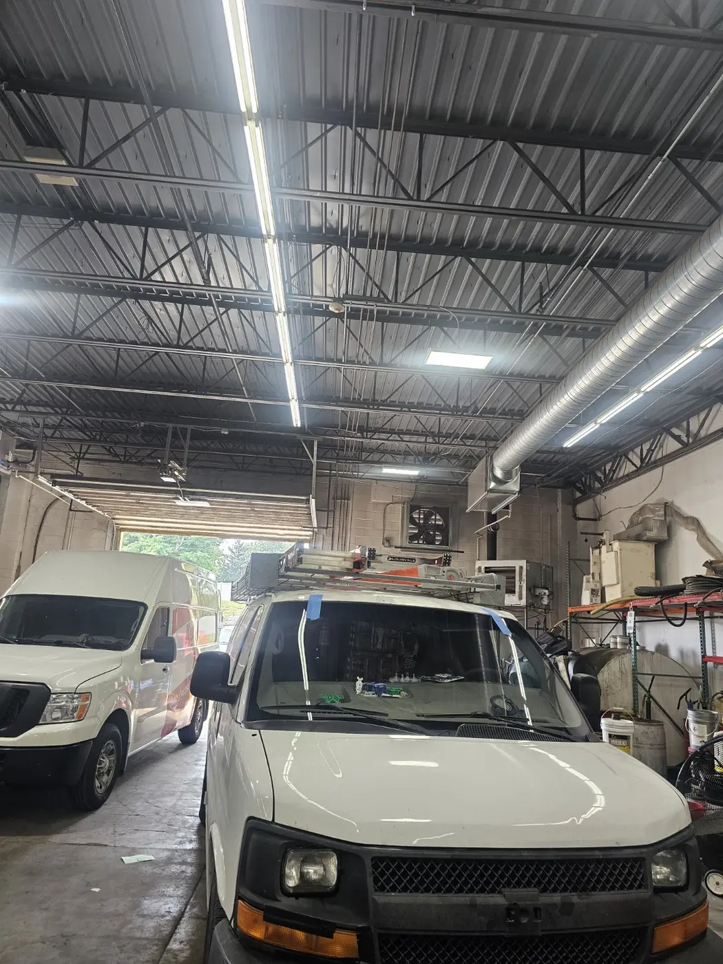 Commercial work vans receiving windshield service at a fleet facility