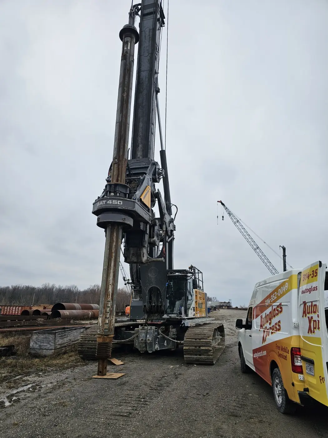Auto Glass Xpress mobile service van beside heavy construction equipment