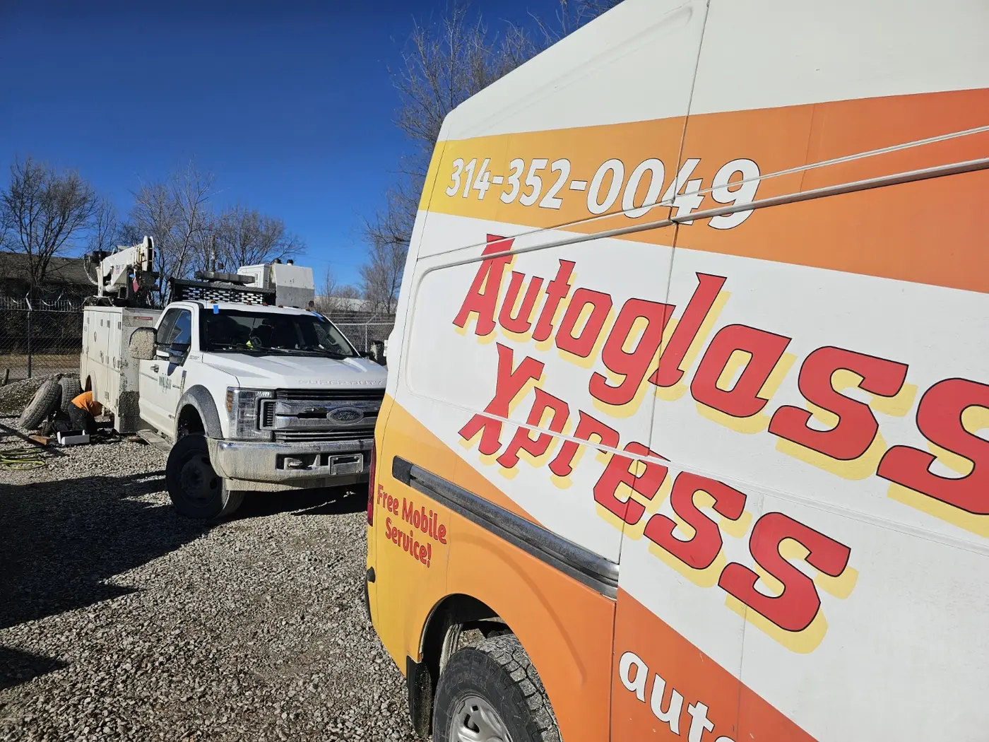 Auto Glass Xpress van beside utility truck during mobile fleet glass service